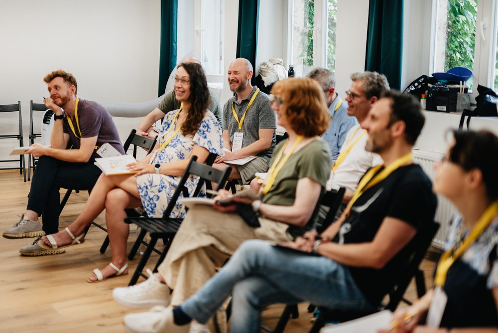 Účastníci workshopu Školy improvizace se zaujetím sledují cvičení